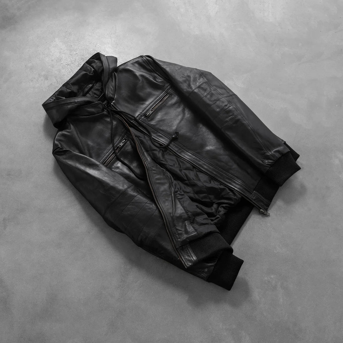 
Passform-Perspektive von Bouncer Biz Black Leather Hooded Bomber Jacket am Model - Natürlicher Faltenwurf im Tageslicht
