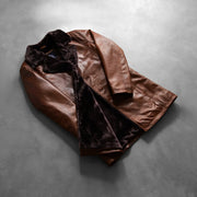 
Passform-Perspektive von Zimtbraun Distressed Leather Fur Ledermantel für Herren am Model - Natürlicher Faltenwurf im Tageslicht